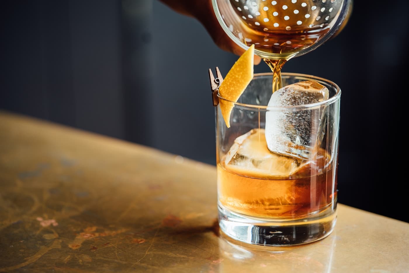 Whiskey being poured over clear ice